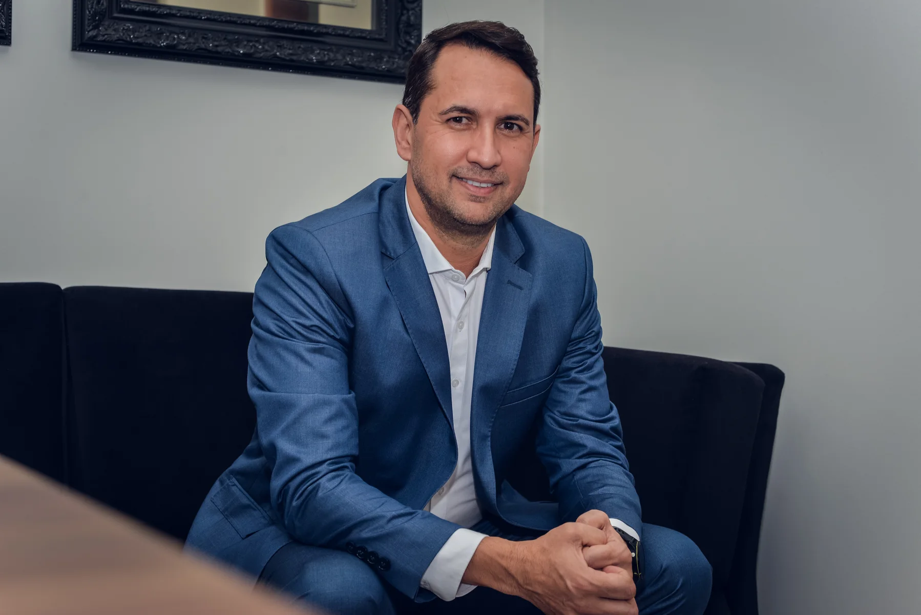 Advogado Andrade sentado no sofá do escritório